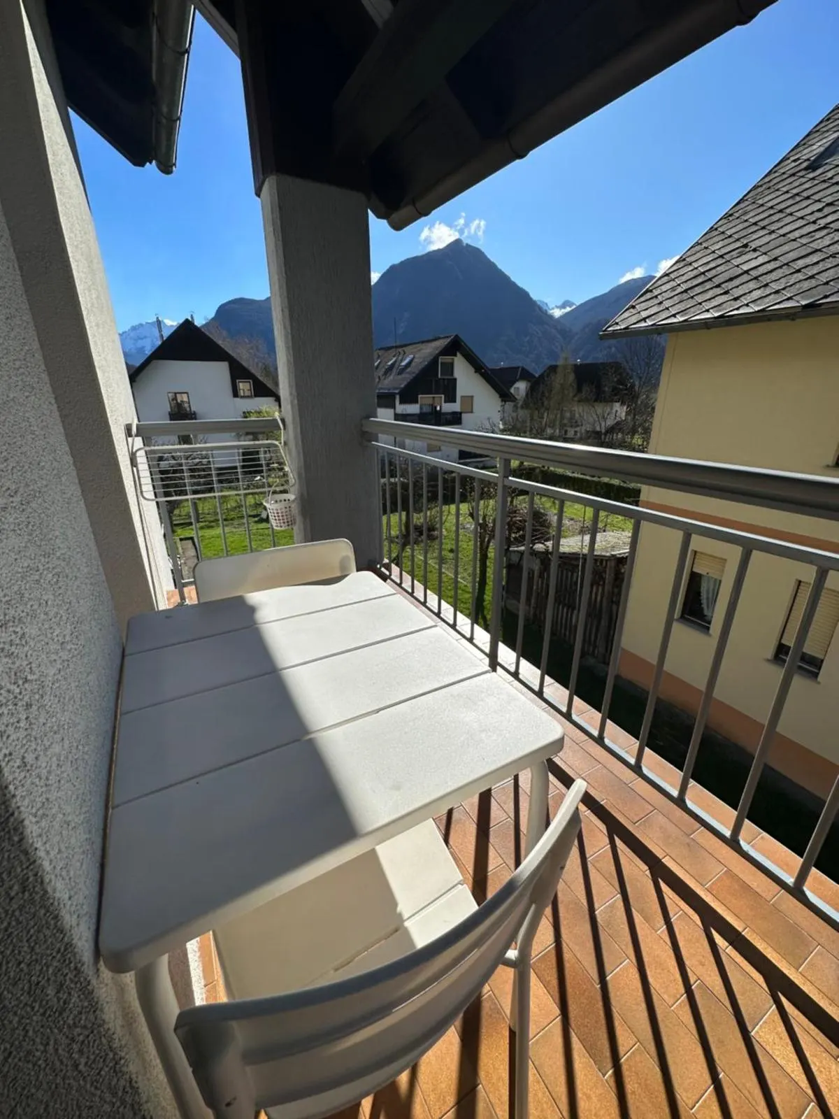 Balkon z mizo in stoli, v ozadju gore