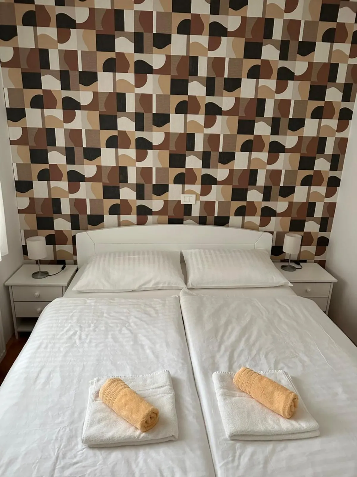 Spalnica z zakonsko posteljo in geometrijsko tapeto